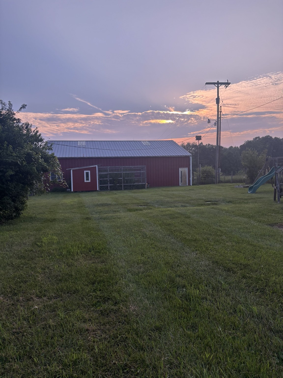 Evening light over the barn and grassy farm grounds
